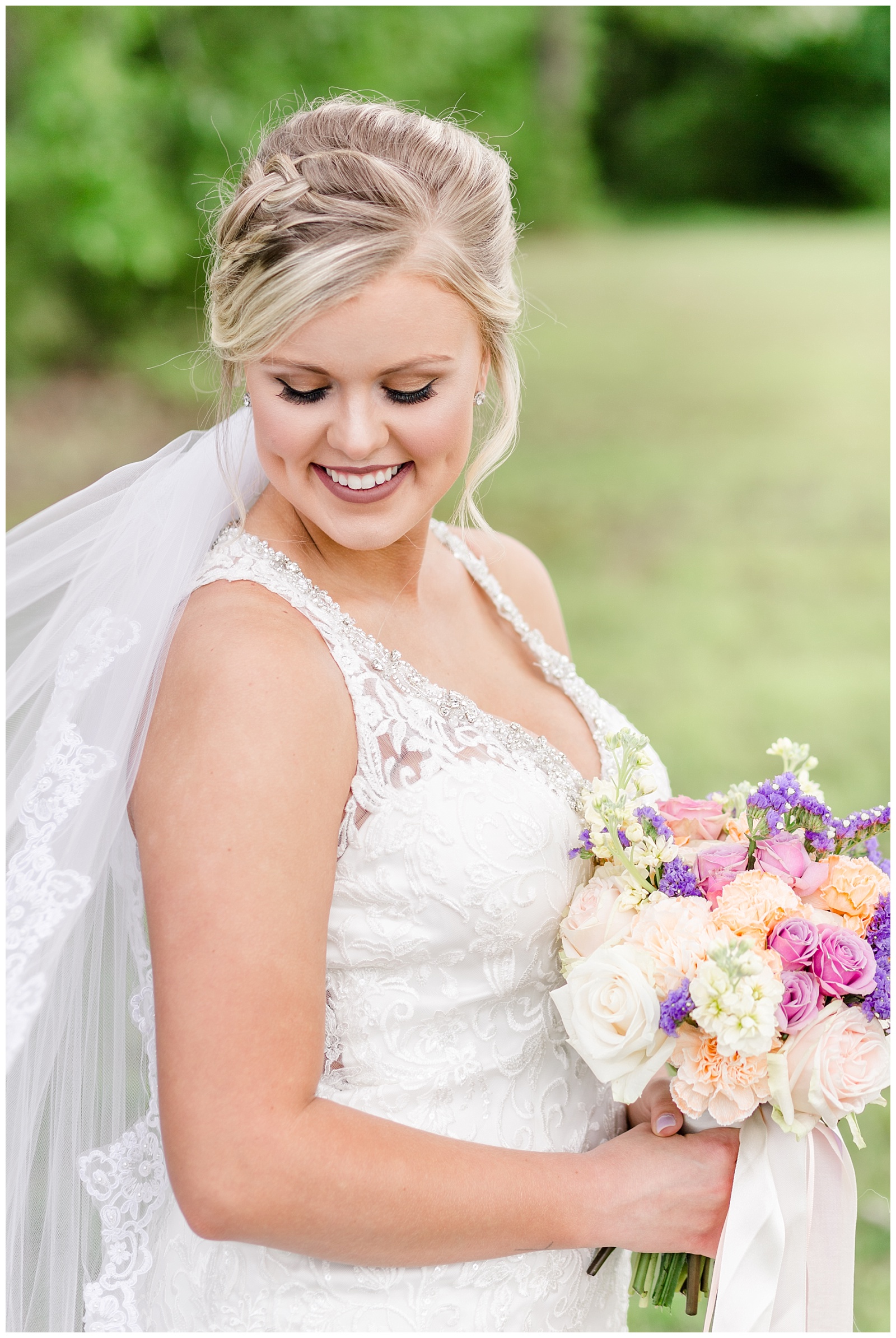 bridal portrait with purple and gold bouquet, flowy veil, mermaid style wedding dress, and an updo with braid