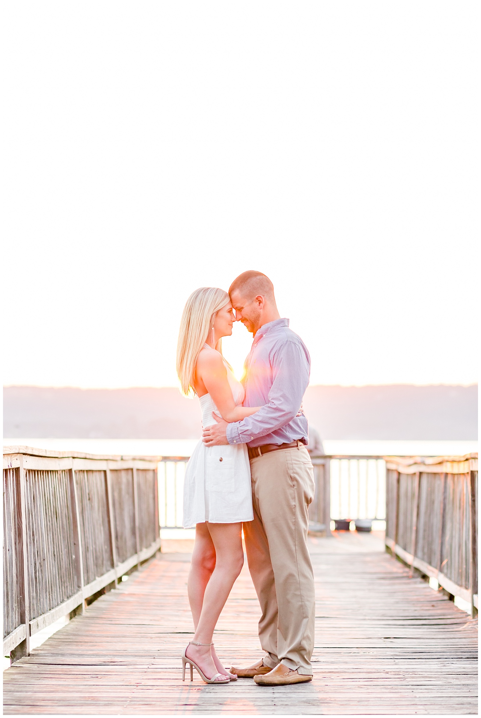 Lake engagement picture on dock at sunset