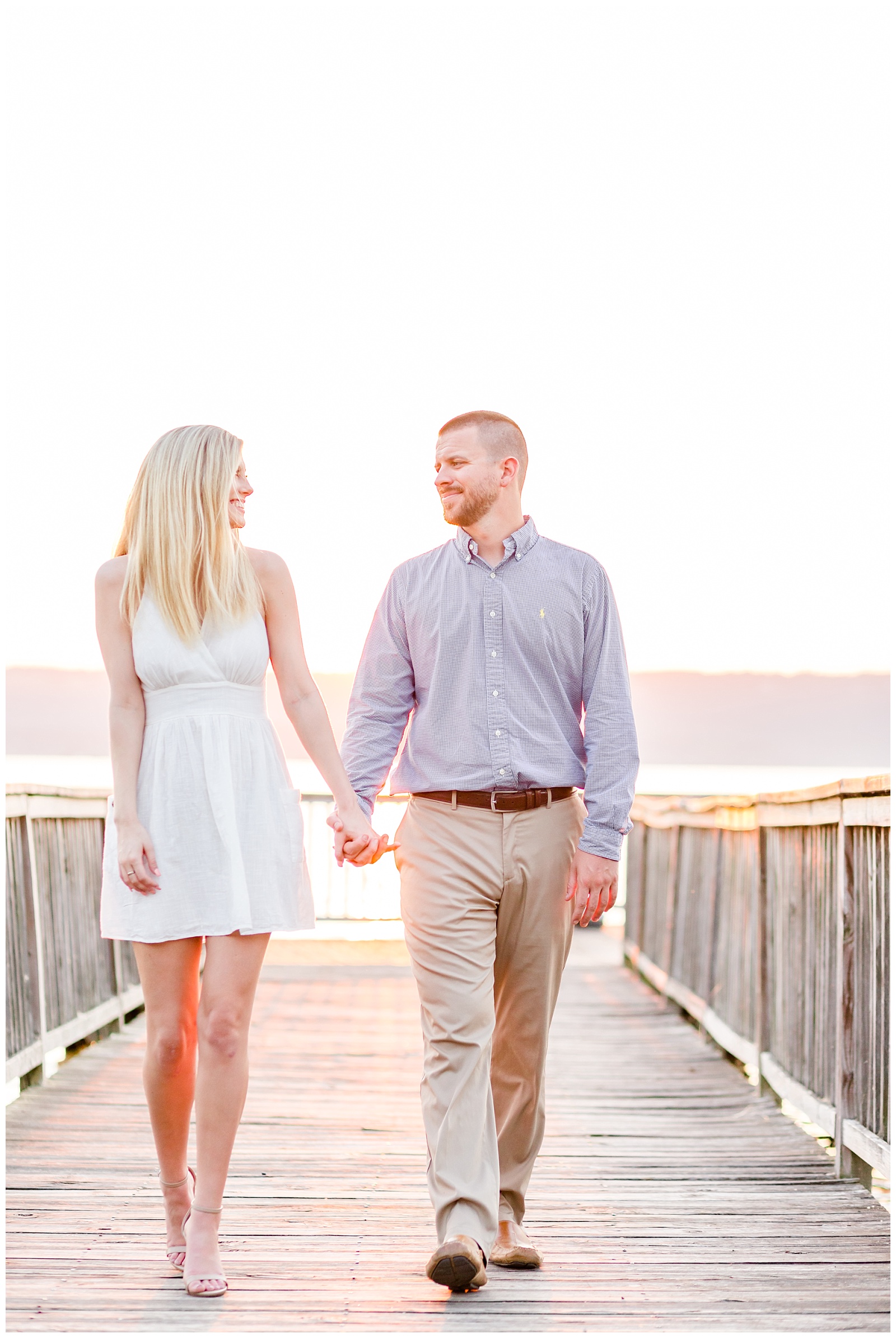 Lake engagement picture on dock at sunset