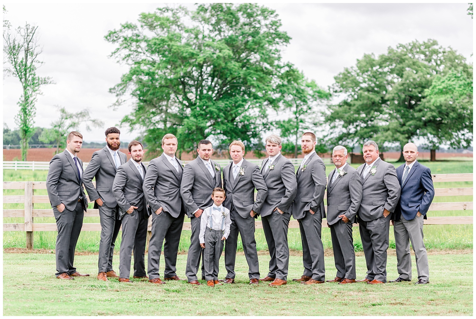groomsmen in grey suits and ring bearer in light blue suspenders