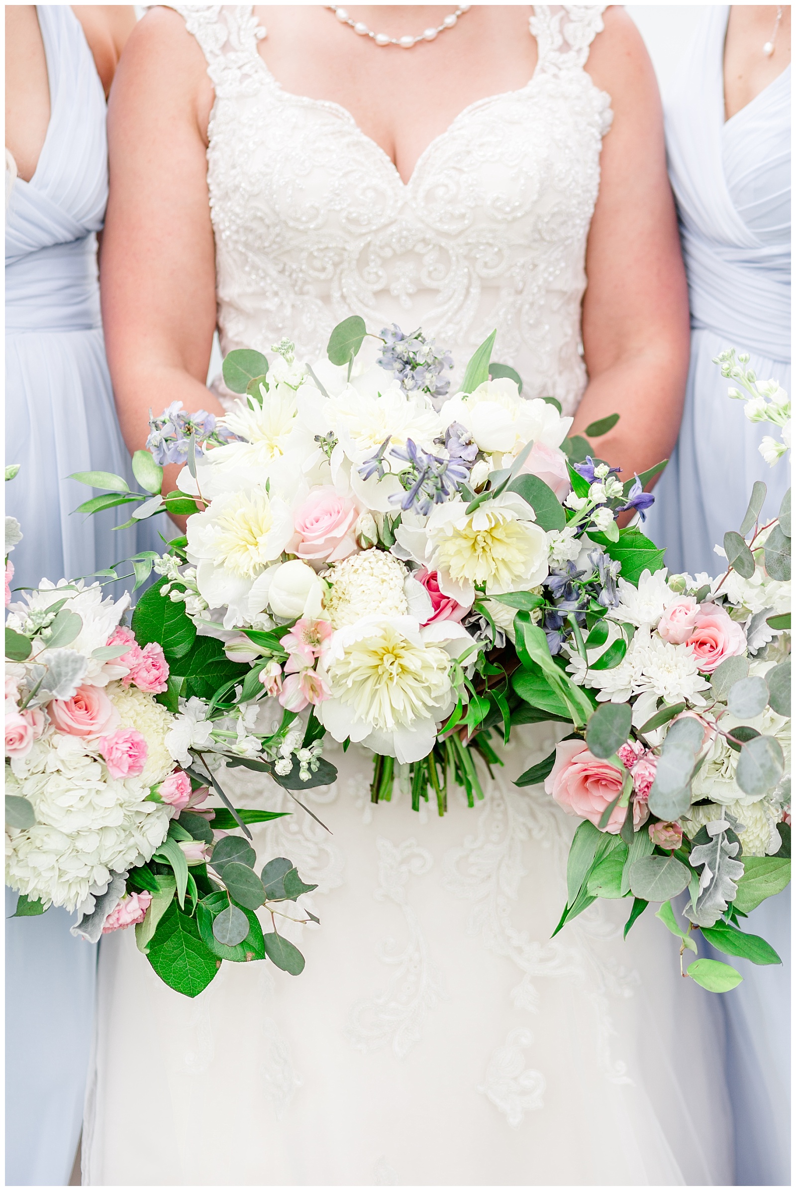 light blue bridesmaids dresses with white yellow pink and blue florals and details at rustic farm venue in alabama