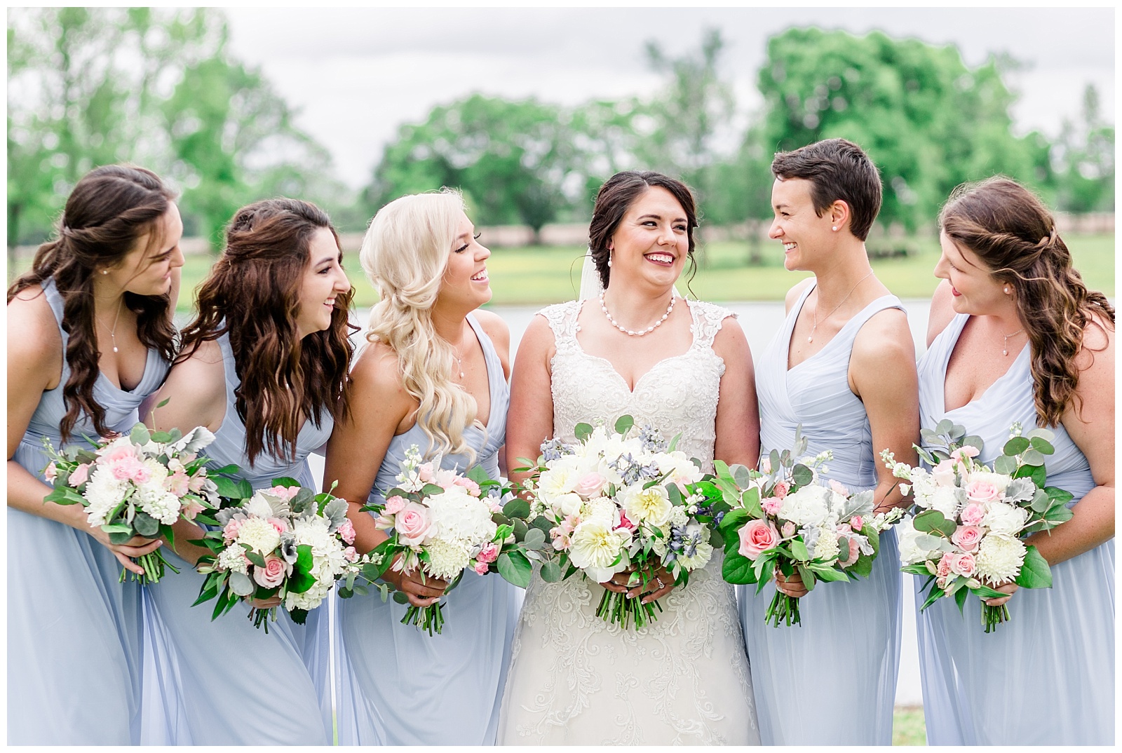 light blue bridesmaids dresses with white yellow pink and blue florals and details at rustic farm venue in alabama