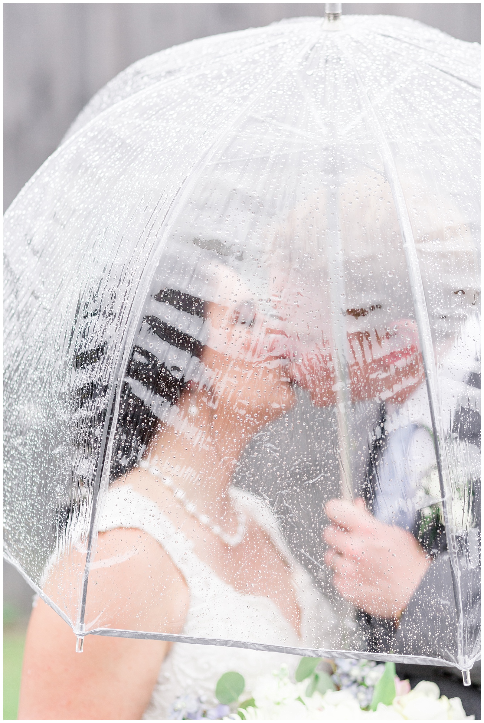 Rustic Barn Wedding Kissing Picture in rain with bubble umbrellas