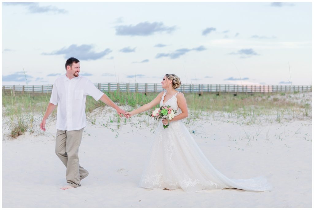 orange beach alabama destination wedding photo on sand dunes with fairytale wedding dress and white and pink floral design with succulents