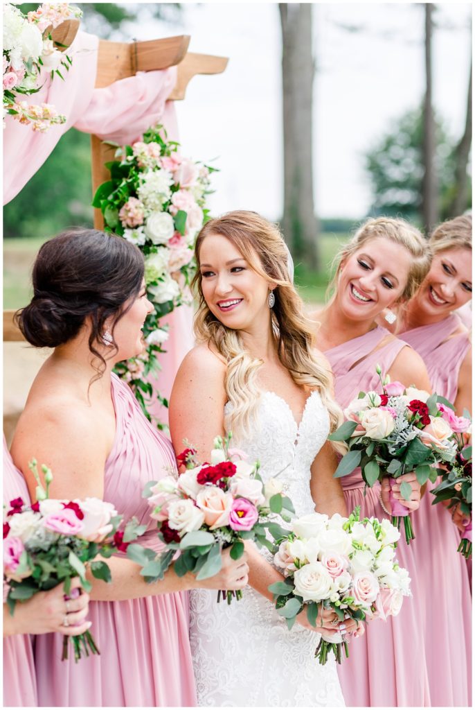 wine and pink wedding photo with bridesmaids in pink dresses and pink and white bouquets