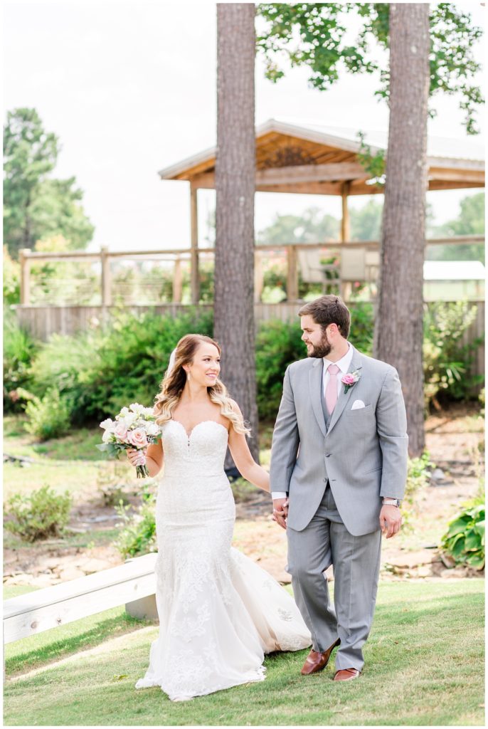 bride and groom wedding photo with strapless lace wedding dress and white pink and wine bouquet and groom in grey suit