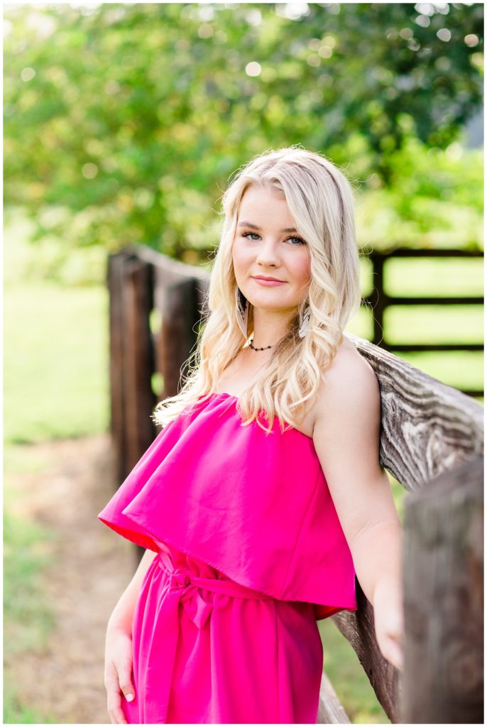 summer senior session on swing in pink jumpsuit