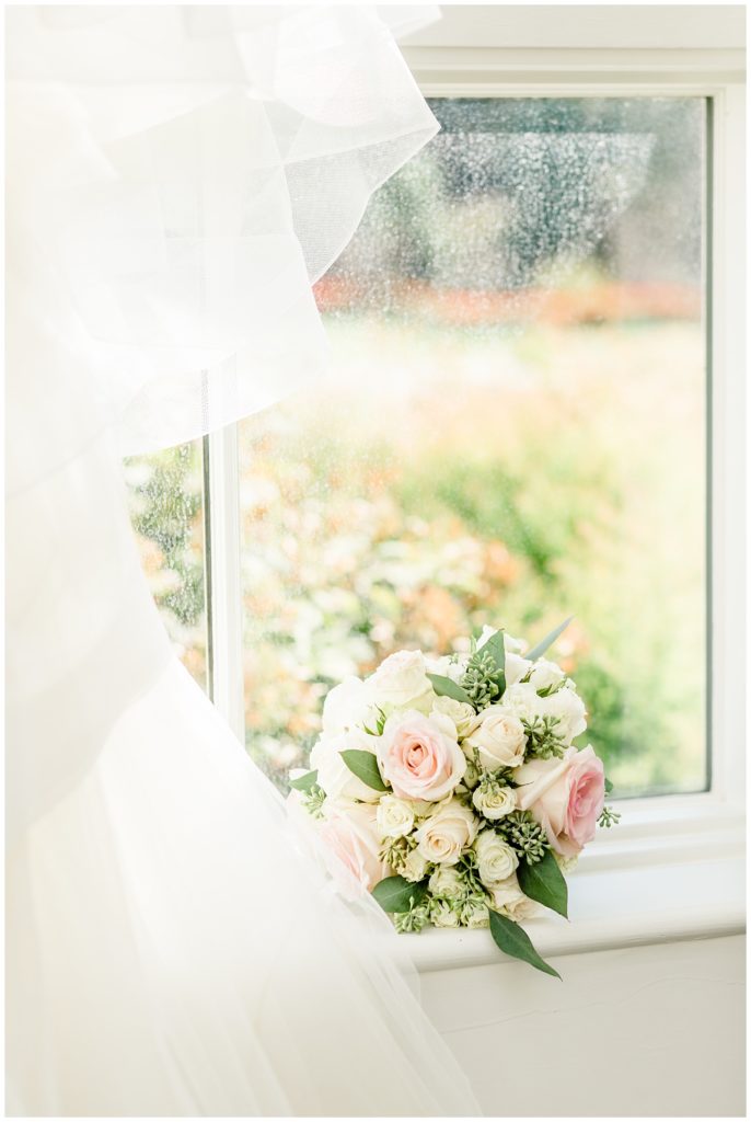pink, white, and green bridal bouquet on window