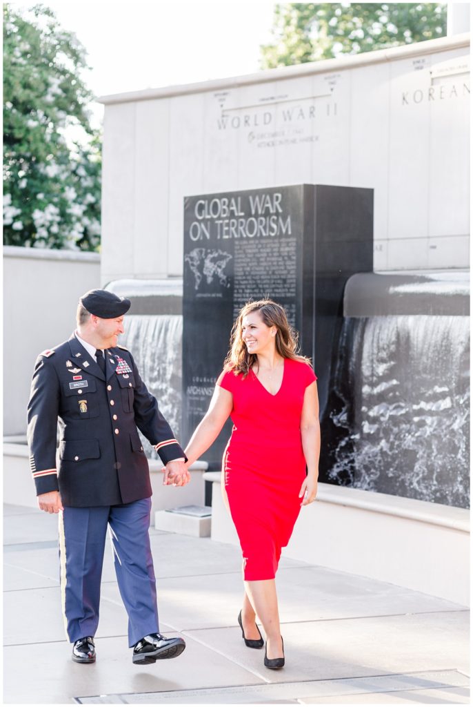 downtown engagement session in military uniform and bright red dress at a veterans memorial park
