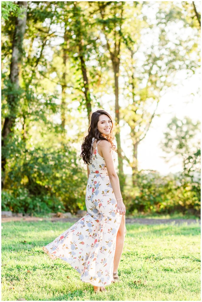 outdoor nature senior session in floral dress at sunset in greenery