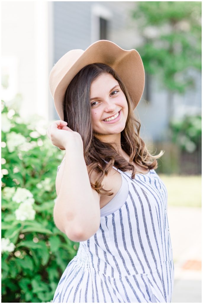 summer downtown senior session in blue striped jumpsuit and floppy hat