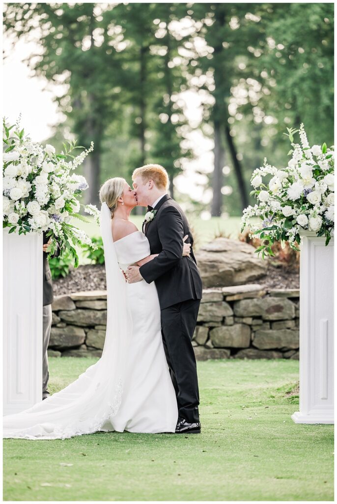 bride and groom kiss at ceremony at the ledges club