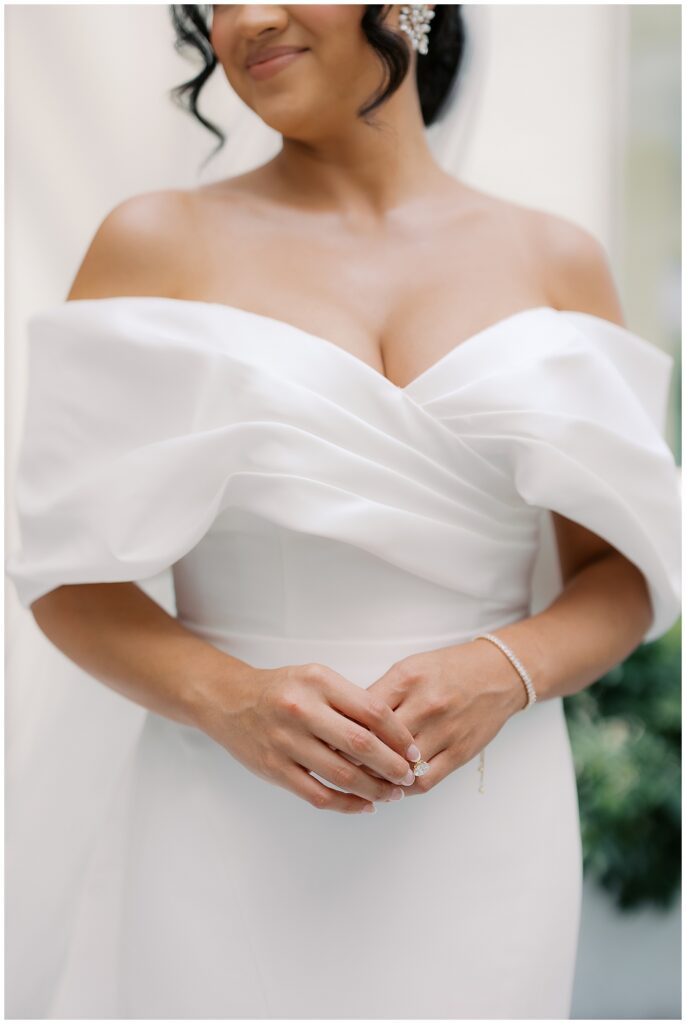bride in off the shoulder wedding dress with oval engagement ring