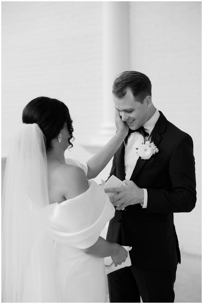 bride wiping tears from groom's cheek during first look and vows